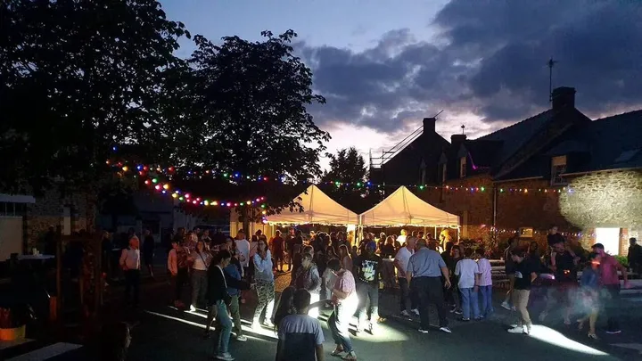 Une fête en extérieur, sous les guirlandes à la tombée de la nuit